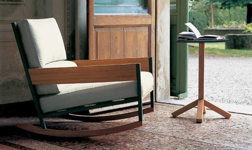 Root Forty Six outdoor side table in front of an armchair with a door in the background