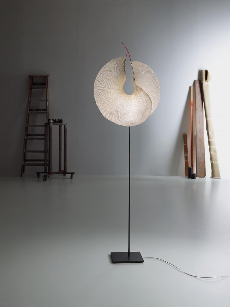 A Yoruba Rose lamp that is on a stand in a room