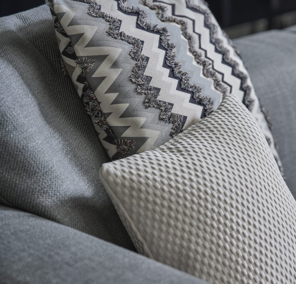Close up of top section of Elissa Sectional in grey with some pillows on top