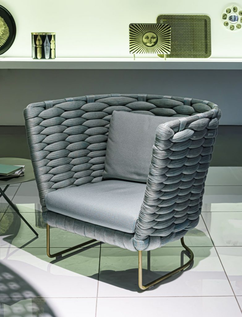 armchair made of a wide multicolor rope base upholstered in fabric in a tone of blue-green gray metal base
