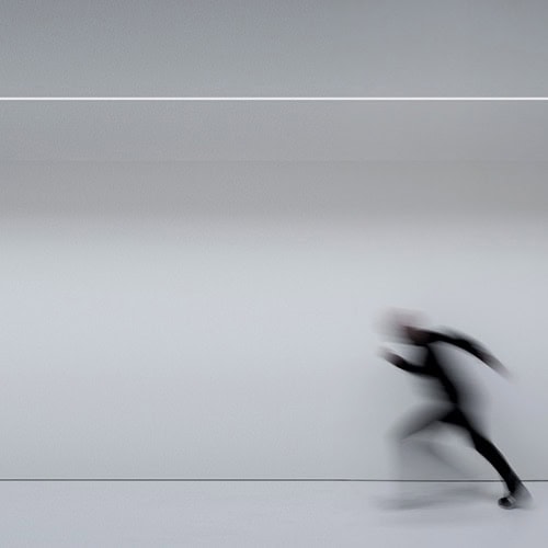 Flash illuminating the ground while a person is running from right to left