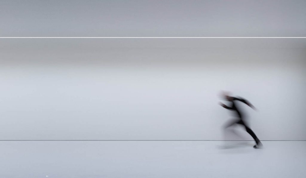 Flash illuminating the ground while a person is running from right to left