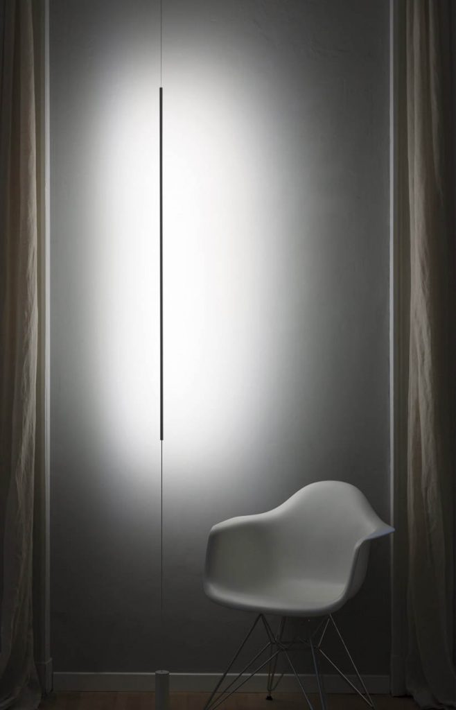 Masai light shining on a white wall with drapes on either side
