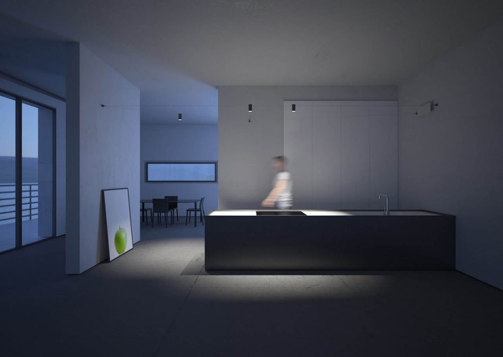 Three Ohm light illuminating a table, person, and floor with a painting leaning against a white wall