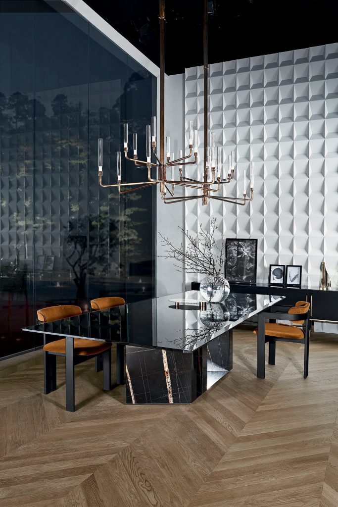 Pair of Epsilon lights hanging over a table with some brown chairs surrounding the table with a white wall background