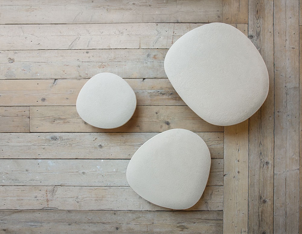 Top view of three Isole tables in different sizes on top of a wooden floor