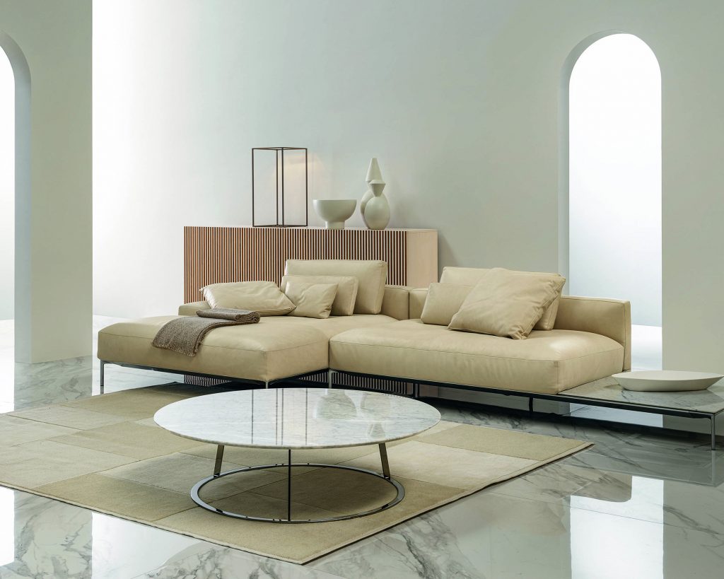 Albino Family wide white top in front of a tan colored sofa on top of a tan colored carpet