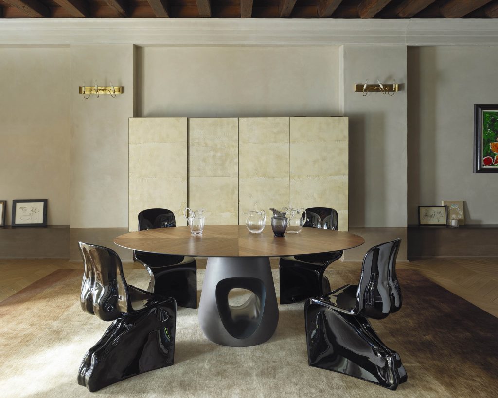 Barbara table surrounded by black chairs with cream cabinets in the background