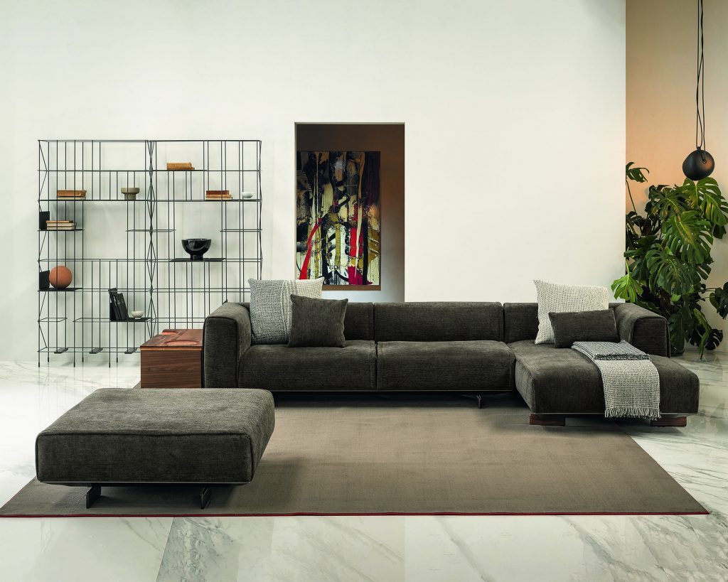Dark colored Coleman on top of a brown rug and white walls behind