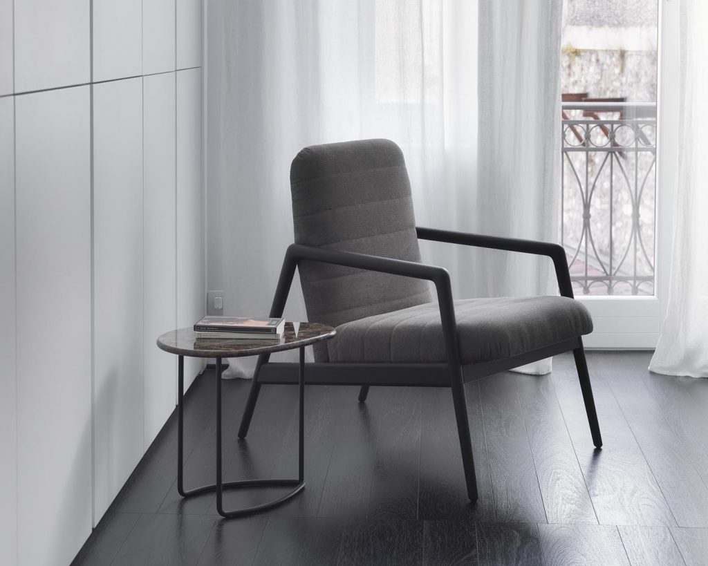 Lily next to a grey chair