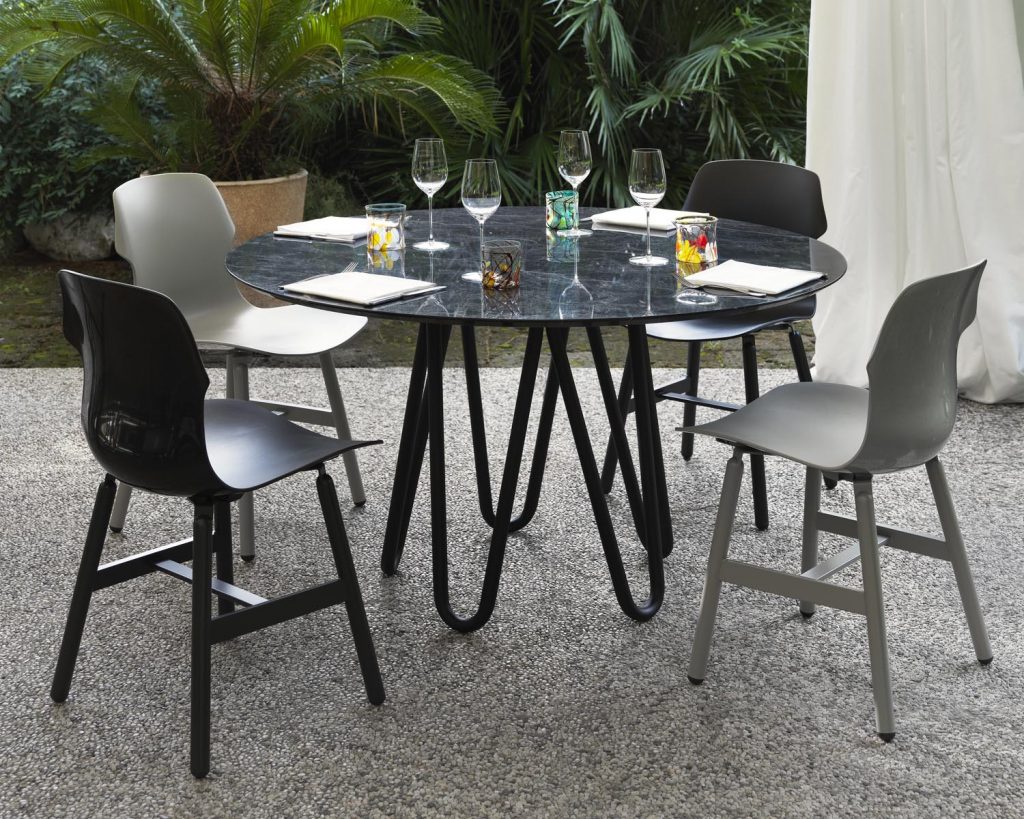 Meduse in black outside surrounded by chairs in different colors