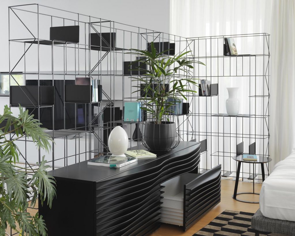 Two Network shelves in front of a white wall with a cabinet in front