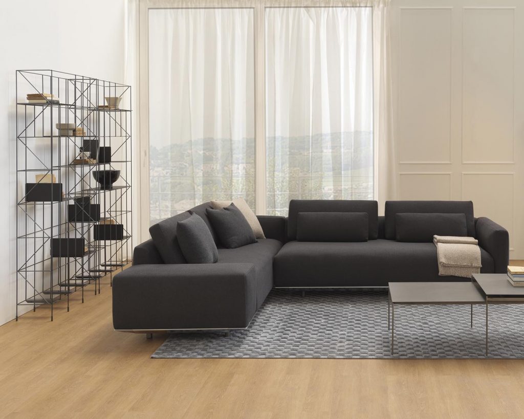 Network on the left side wall with a sofa to the right of the shelve