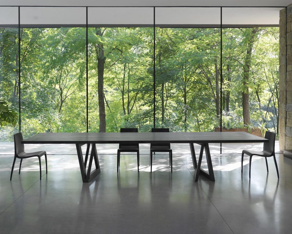 Quadror Three in front of tall windows with chairs surrounding table