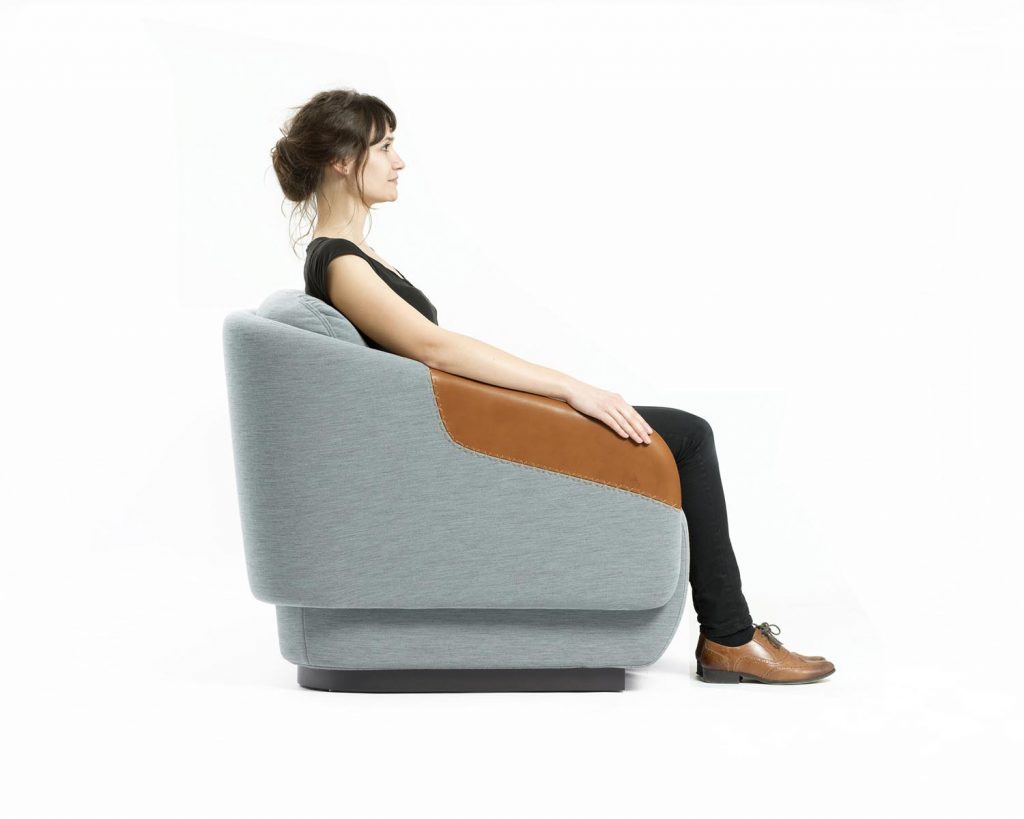 Side angle of a Worn chair in grey with brown armrests