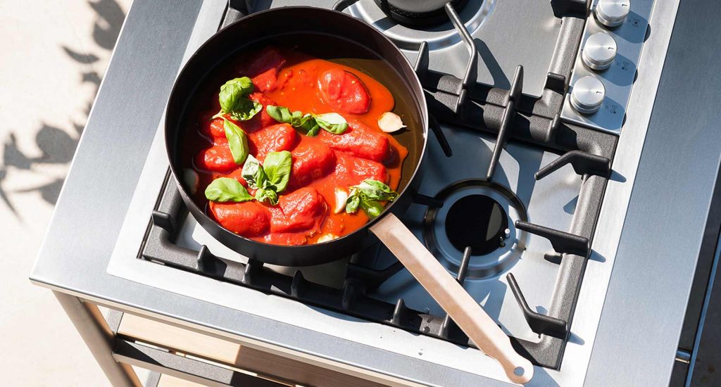 A pot with vegetables on top of the burners of the Norma One Cooking module
