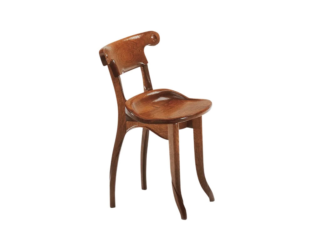The BD Batllo Chair features graceful, curving lines and an ergonomic seat. Made from rich, medium-brown wood, its smooth finish accentuates the fluid, handcrafted design and natural grain.