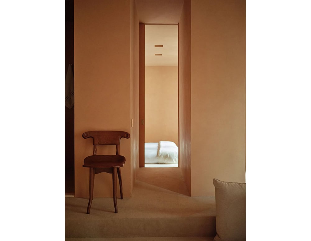 The BD Batllo Chair features sculpted wood with fluid, organic lines. Its compact form and expressive backrest evoke handcrafted artistry, presented in a rich, warm brown finish that complements minimalist interiors.