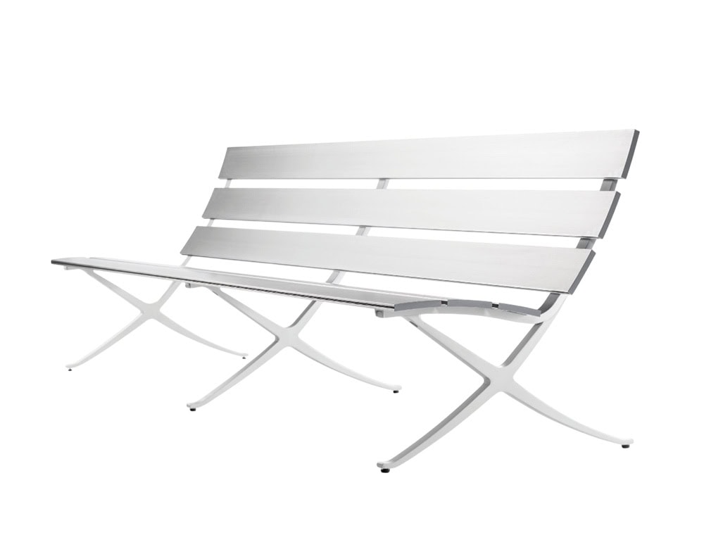 The BD Bench B Outdoor features slatted aluminum seating and backrest components. Its minimalist structure delivers a durable and versatile solution for public or private outdoor spaces.