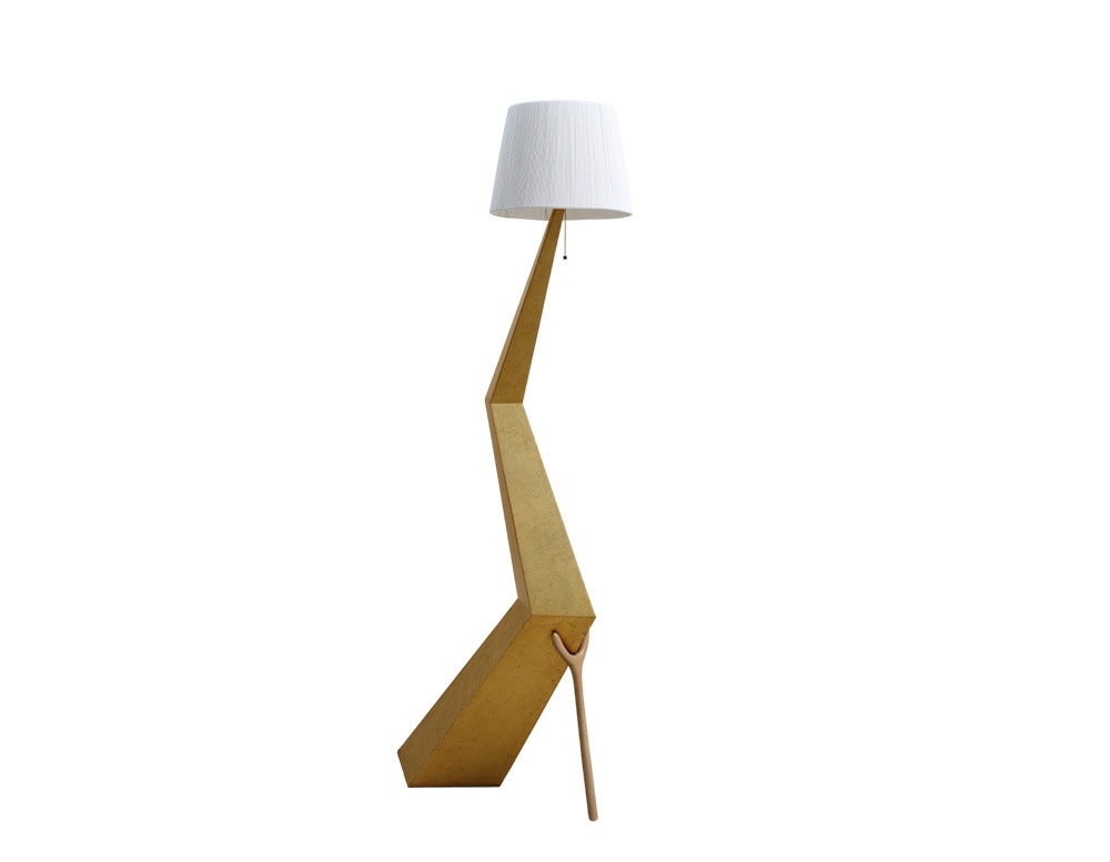 The BD Bracelli Sculpture Floor Lamp features an angular, architectural gold-toned structure paired with a crisp white pleated lampshade. Its sculptural silhouette creates a striking and contemporary floor accent.
