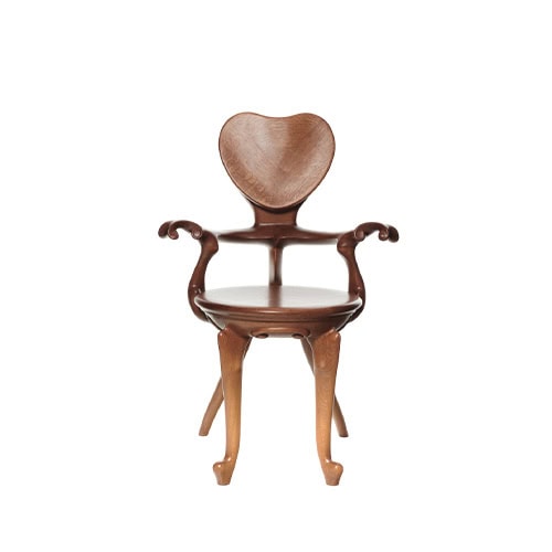 The BD Calvet Armchair highlights its heart-shaped backrest, flowing armrests, and rounded seat. Crafted in warm-toned wood, the chair’s smooth surface and visible grain accentuate its organic elegance.