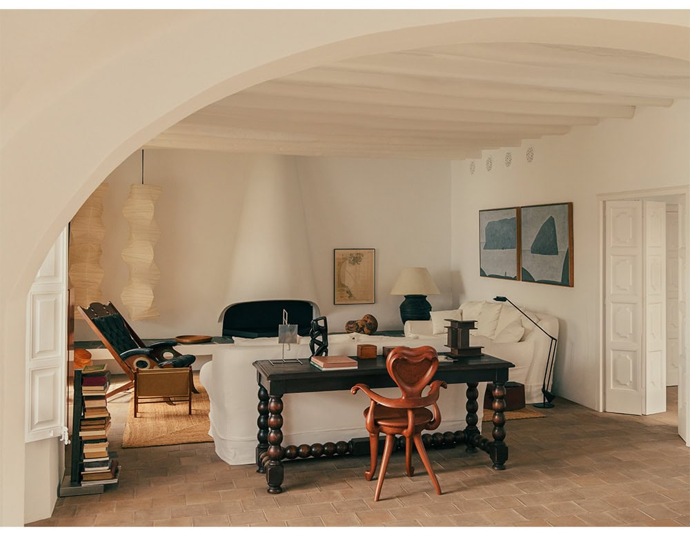 The BD Calvet Armchair adds an expressive sculptural accent to this warm and eclectic living space. Positioned by a dark wood desk, its flowing organic lines contrast with the room's rustic beams and soft neutral tones.