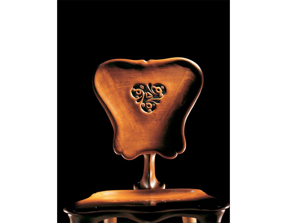 The BD Calvet Chair features a sculptural wooden backrest with fluid contours and a delicate floral relief at its center. Its rich finish and organic lines create an elegant piece with a distinct decorative character.