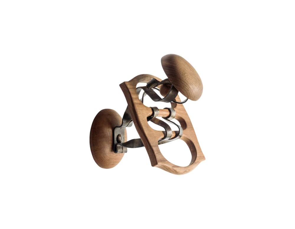 The BD Calvet Hanger, crafted in oak with iron accents, features sculptural forms with rounded supports and flowing metal hooks.