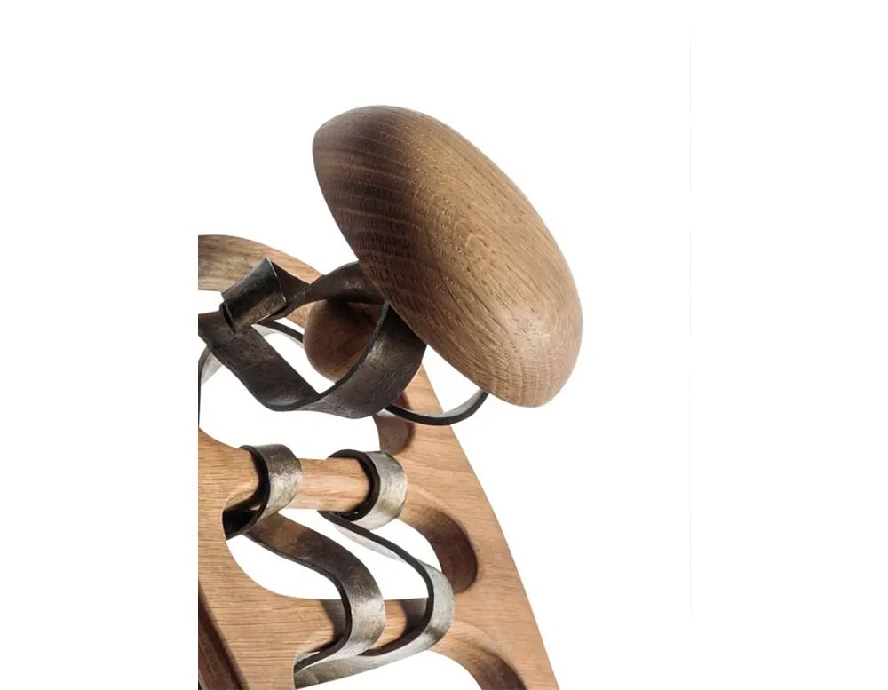 Detail of the BD Calvet Hanger shows its organic wooden knob and the elegantly curved metal hooks extending from the carved wooden base.