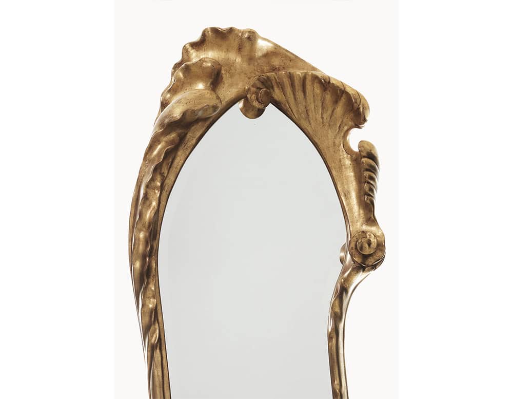 The BD Calvet Mirror displays an organic and flowing silhouette, with its golden frame curving around the glass. The carved details evoke natural forms, giving the mirror an expressive, sculptural quality.