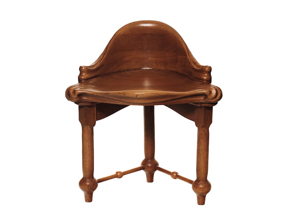 A front-facing perspective of the piece, showcasing its handcrafted woodwork, organic curves, and ornamental legs.