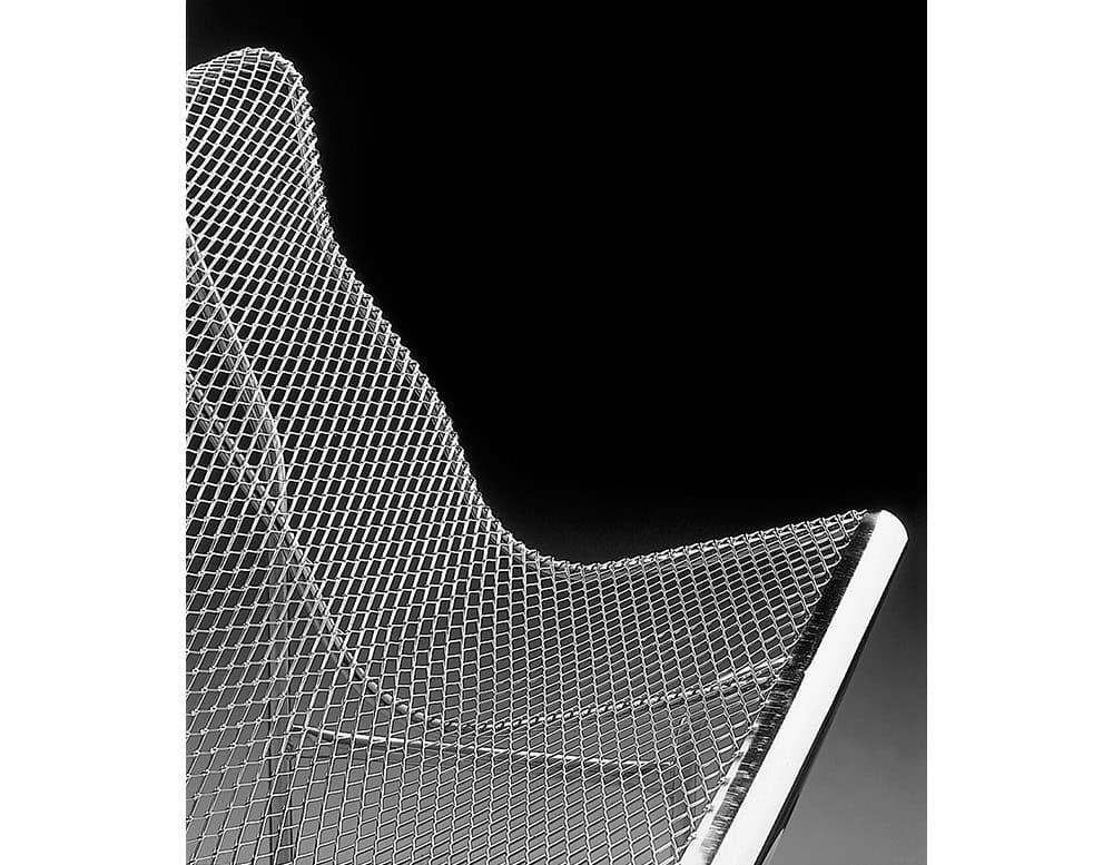 A close-up view of the BD Catalano bench highlights its sculptural profile and diamond-shaped perforated mesh. The fluid lines and ergonomic contours are engineered for both comfort and durability in outdoor spaces.