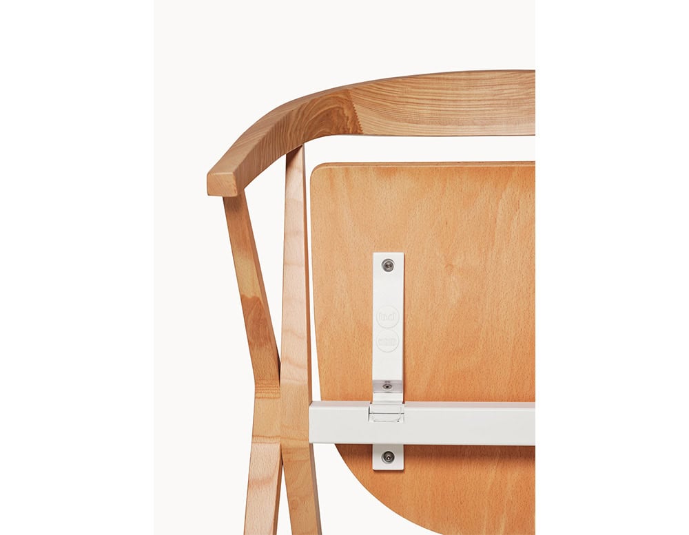 Close-up of the BD Chair B, highlighting the wood grain and the underside folding mechanism with engraved branding details.