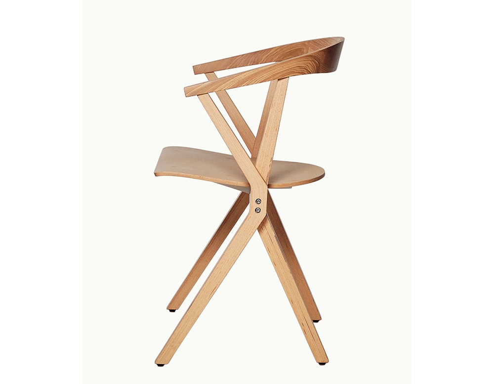 The BD Chair B highlights its characteristic X-shaped structure and natural wood finish, merging comfort with refined craftsmanship.
