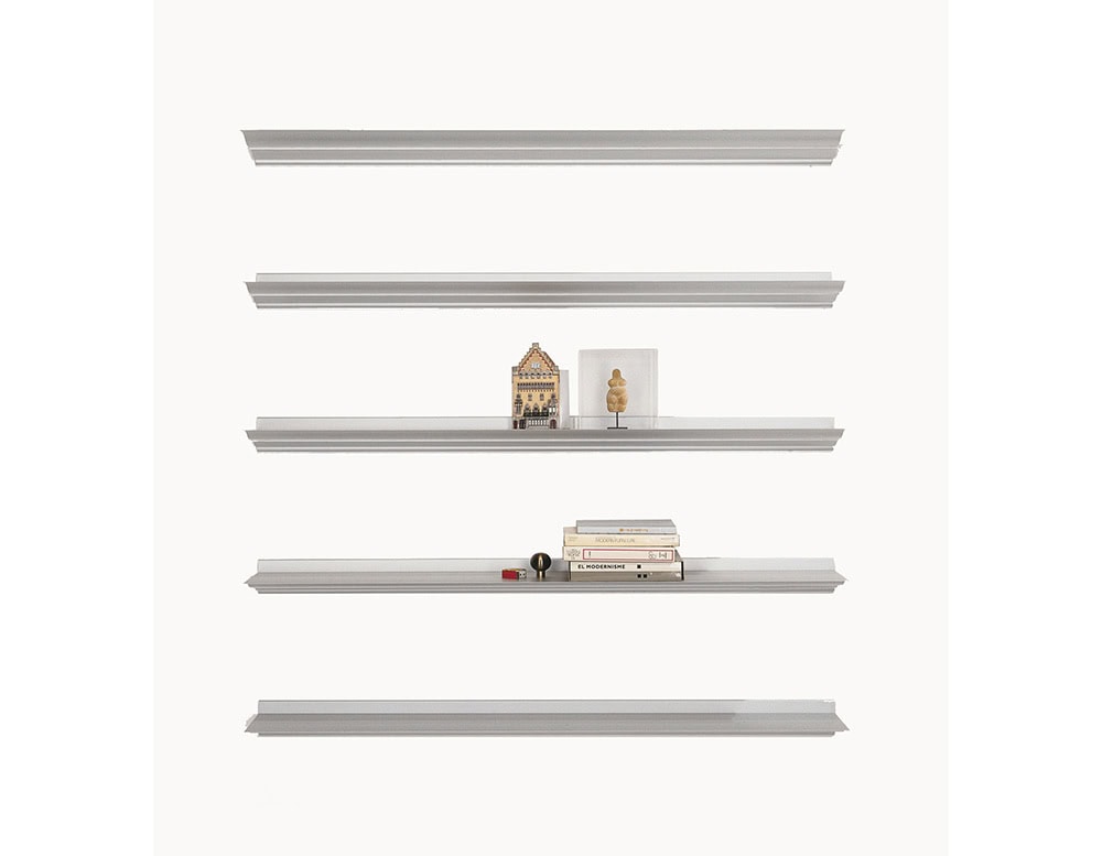 Set of BD Cornisa Shelves mounted vertically to showcase a selection of books and objects, emphasizing the versatile sizing that adapts to various display needs.