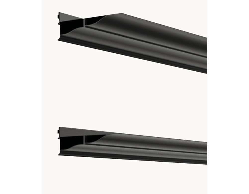Close-up of the BD Cornisa Shelf in matte black, highlighting its cornice-inspired profile with integrated grooves designed to securely hold books or decorative objects in place.