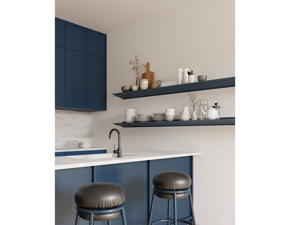 The BD Cornisa Shelf is shown in a deep navy blue finish, with the floating shelves holding an assortment of ceramics, plates, and kitchen essentials, complementing the cabinetry and marble countertop.