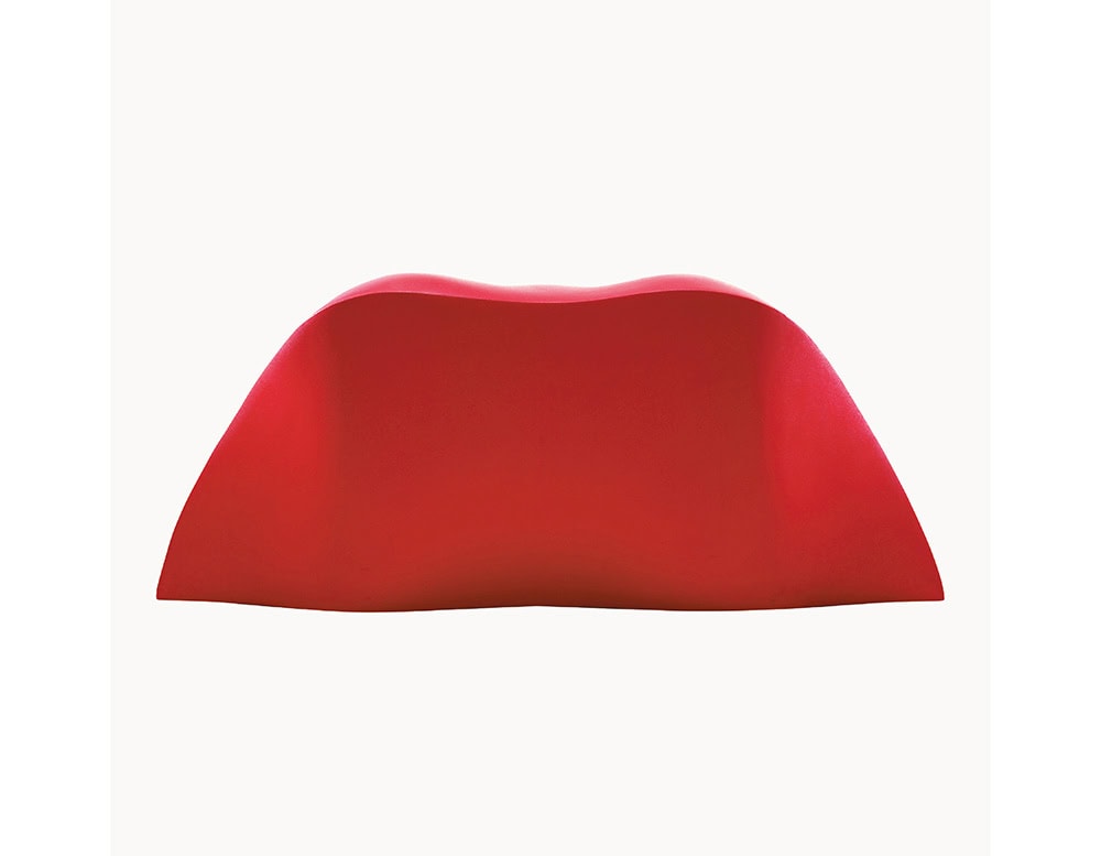 A rear view of the Dalilips Sofa highlights its smooth, continuous silhouette. The bold red finish accentuates the playful curvature, making the piece instantly recognizable from any angle.