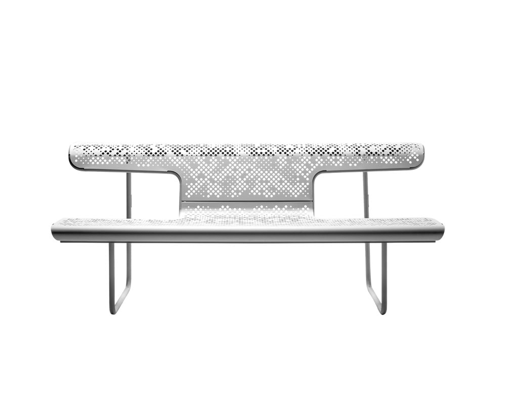 The El Poeta bench in white features a layered seat and backrest with intricate perforations. Its metal frame and slender vertical supports give it a light and sculptural presence while maintaining functional outdoor durability.