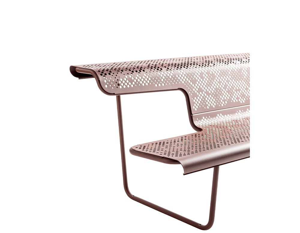 Close-up of the El Poeta bench, highlighting its layered seat and backrest made from perforated metal. The rounded edges and delicate pattern create a lightweight, airy appearance, while the minimal frame supports the structure elegantly.