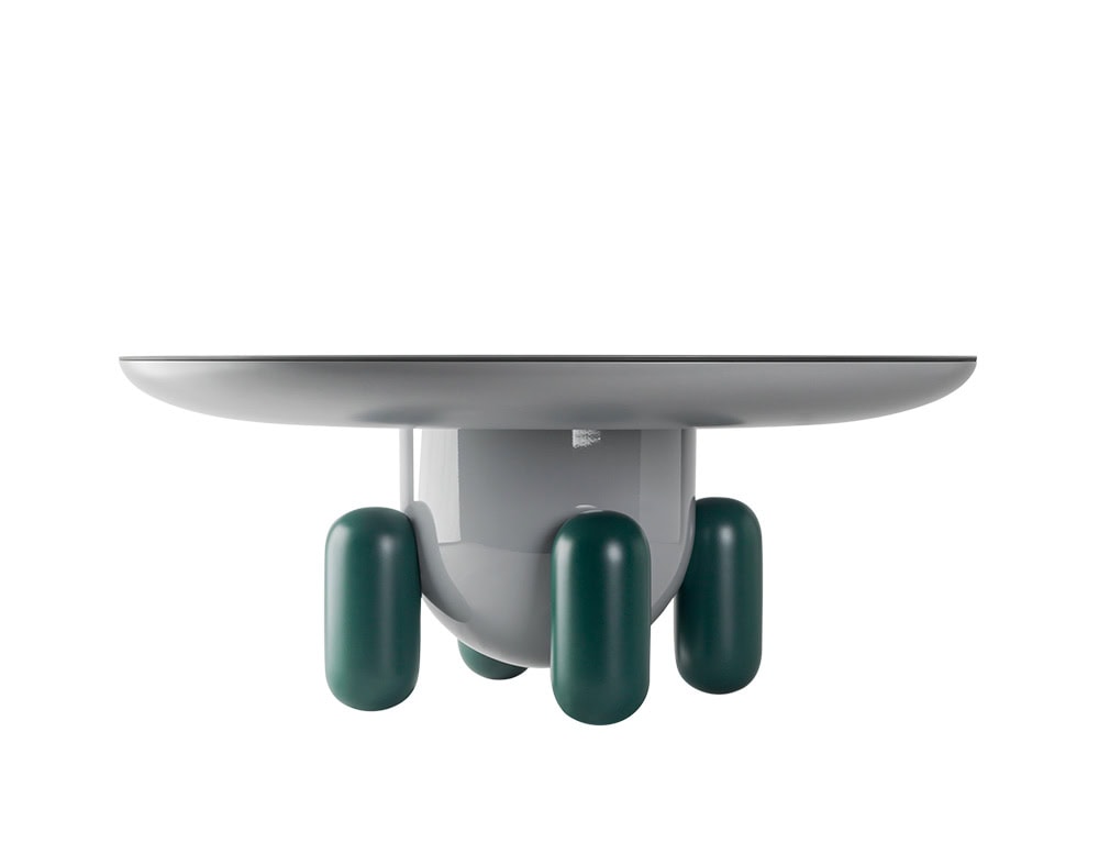 A playful side table with a soft grey top and bold green legs. Its rounded forms and glossy finish give it a lighthearted, contemporary character.