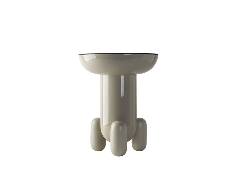 A playful side table with sculptural charm. The design features a rounded glossy top in grey, supported by a cylindrical base with four bulbous legs that add a whimsical touch.