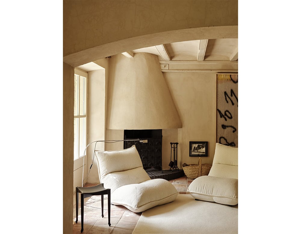 The BD Flamingo Floor Lamp is positioned beside a lounge chair in this warm, rustic interior. Its slender stem and long adjustable arm gracefully arc over the seating area, providing focused lighting without overpowering the room’s cozy ambiance.