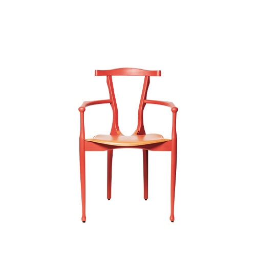 The red BD Gaulino Chair with a tan leather seat. The chair’s fluid silhouette and slender frame create a refined, contemporary statement.