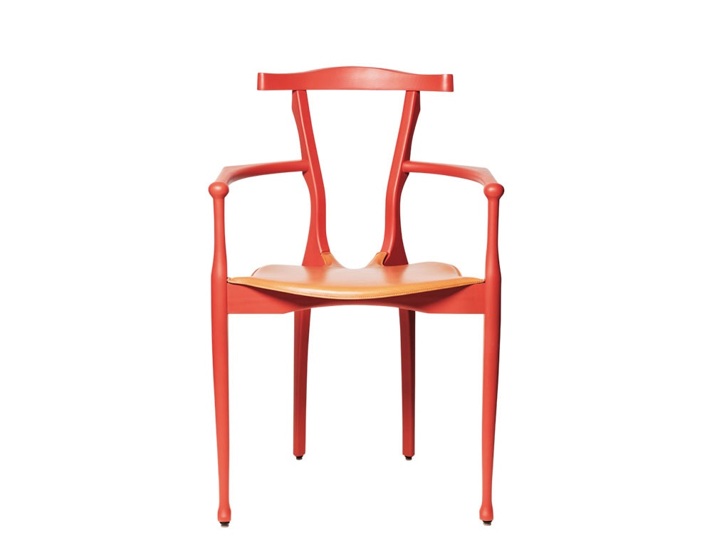 Front view of the red BD Gaulino Chair featuring a tan leather seat. The image highlights the chair’s organic curves, slender legs, and distinctive sculptural backrest.