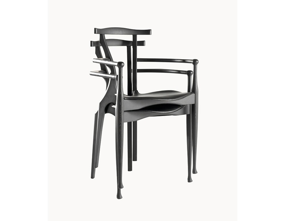 A stack of black BD Gaulino Chairs highlights their graceful, sculptural frame and practical stackable design.