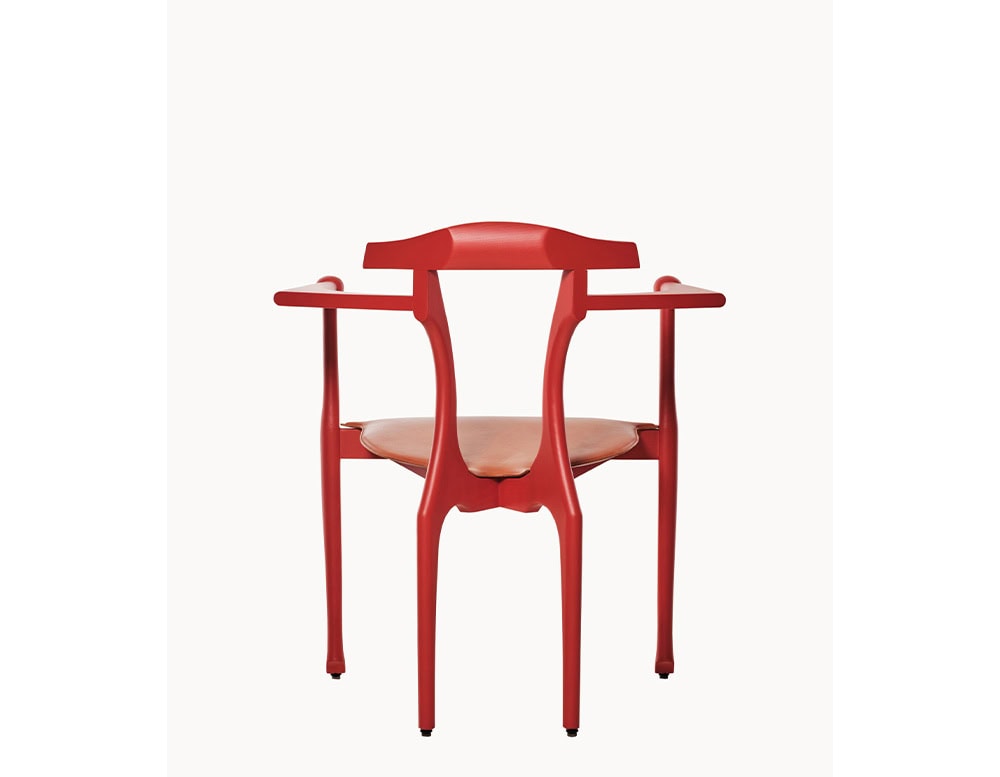 Striking red ash wood frame with fluid, sculptural lines and a hand-stitched tan leather seat. Its bold silhouette and artisanal craftsmanship blend elegance with a modern artistic edge.