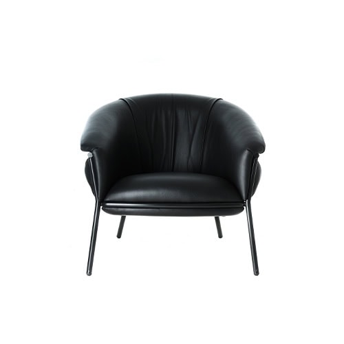 Front-facing image of the BD Grasso Armchair in black leather highlights its plump cushions nested within a thin tubular structure. The exaggerated softness of the seat and backrest is designed to contrast with the minimal metal frame.