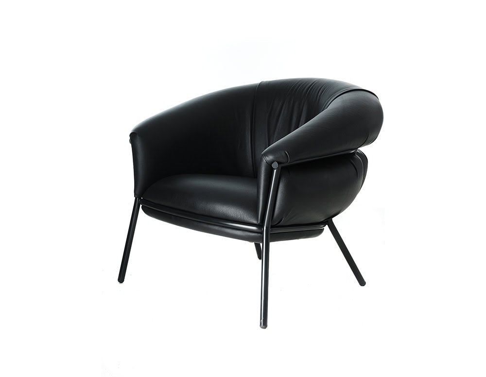Front angle of the BD Grasso Armchair in black leather showcases its plump, overfilled cushions resting within a minimal steel frame. The generous padding embraces the user, while the sleek structure keeps the silhouette contemporary and light.