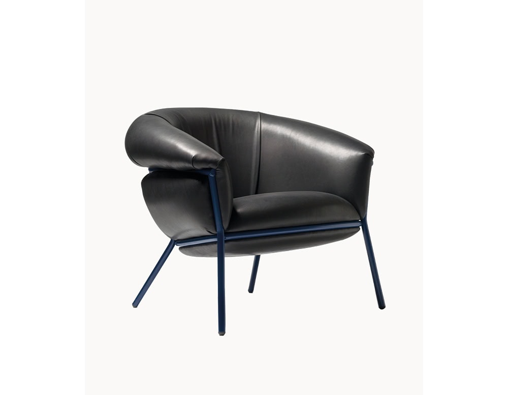 The BD Grasso Armchair combines generous leather upholstery with a relaxed, overstuffed look. Its deep black seat contrasts with a slender blue steel frame that gives it balance and structure.